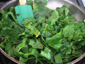 Chard added to skillet and tossed with oil and seasonings