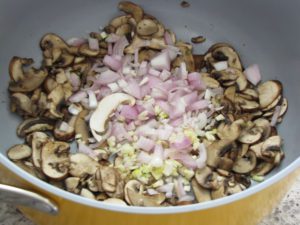 Mushrooms cooked down, add shallots and garlic